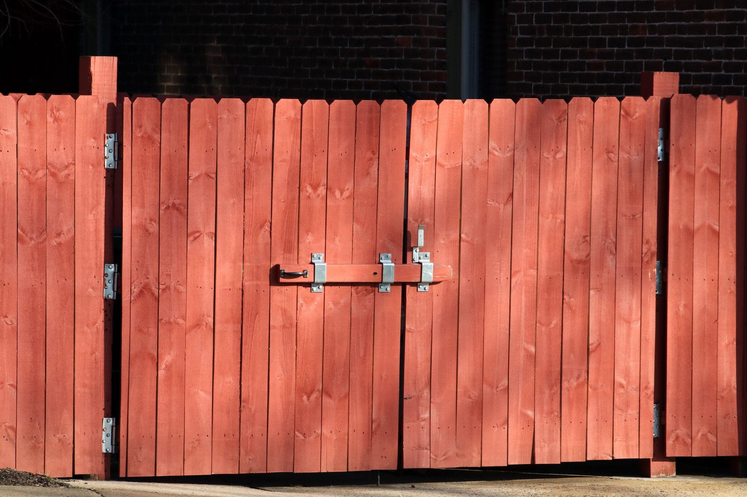 Driveway gate: Stain on a red wood double gate with a cane bolt and slide latch